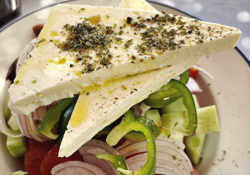 Griekse salade met een plak feta, tomaat, ui en oregano